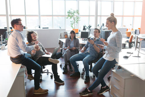 Group of a young business people discussing business plan in the office - INGF12252