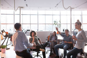 Eine Gruppe junger Geschäftsleute bespricht im Büro einen Geschäftsplan - INGF12261