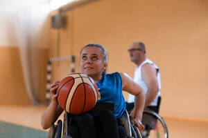 A young woman playing wheelchair basketball in a professional team. Gender equality, the concept of sports with disabilities. High quality photo. a young woman playing wheelchair basketball in a professional team. Gender equality, the concept of sports with disabilities. - INGF12293