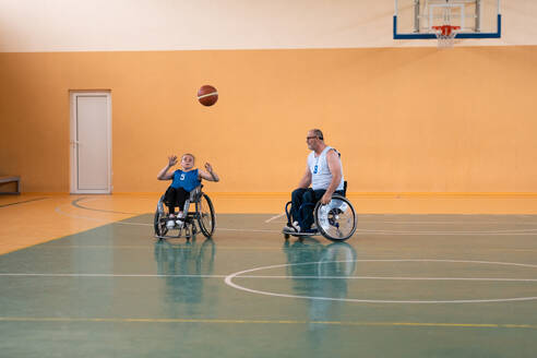 A young woman playing wheelchair basketball in a professional team. Gender equality, the concept of sports with disabilities. High quality photo. a young woman playing wheelchair basketball in a professional team. Gender equality, the concept of sports with disabilities. - INGF12294