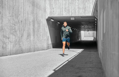 Fitness, sport and healthy lifestyle concept - young man running out of tunnel. young man running out of tunnel - INGF12336