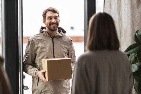 Versand, Transport und Menschen Konzept - Zusteller mit Paketkasten und Kunde zu Hause. Zusteller mit Paketkasten und Kunde zu Hause - INGF12337