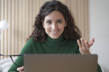 Smiling young Italian woman teacher tutor talks with students during online lesson on laptop, records educational training, pleasant female freelancer communicating with client via video call. Smiling young Italian woman teacher tutor talks with students during online lesson on laptop - INGF12463