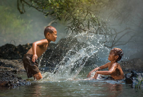 Asia children on river / The boy friend happy funny playing water in the water stream in countryside of living life kids farmer rural people - INGF12639