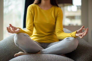 Close Up Of Peaceful Woman Meditating Sitting In Chair At Home - INGF12644