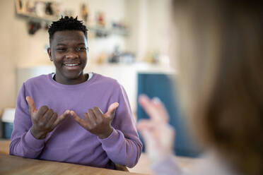 Teenage Boy And Girl Having Conversation Using Sign Language - INGF12645