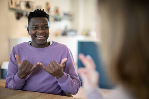 Teenage Boy And Girl Having Conversation Using Sign Language - INGF12645