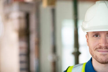 Cropped Portrait Of Male Construction Worker On Building Site Wearing Hard Hat - INGF12653