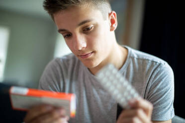 Teenage Boy With Mental Health Problems Taking Medication At Home - INGF12662