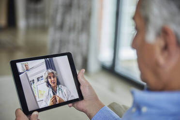 Man Having Remote Consultation With Doctor At Home Using Digital Tablet - INGF12678