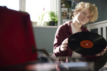 Teenage Girl Playing Vinyl Records On Record Player At Home In Bedroom - INGF12681