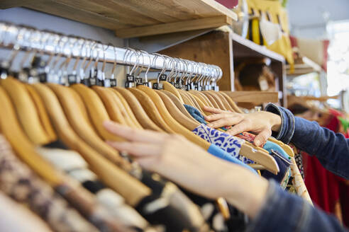 Close Up Of Young Woman Buying Used Sustainable Clothes From Second Hand Charity Shop - INGF12702