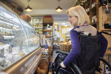 Woman In Wheelchair Shopping For Food In Delicatessen - INGF12710