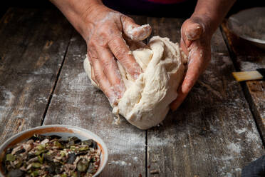 Woman making dough on wooden table close-up. - INGF12745