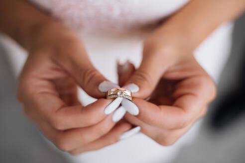 Woman holds precious wedding ring in her arms - INGF12763