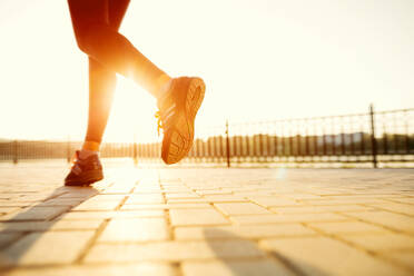 Runner feet running on road closeup on shoe. woman fitness sunrise jog workout welness concept. - INGF12808