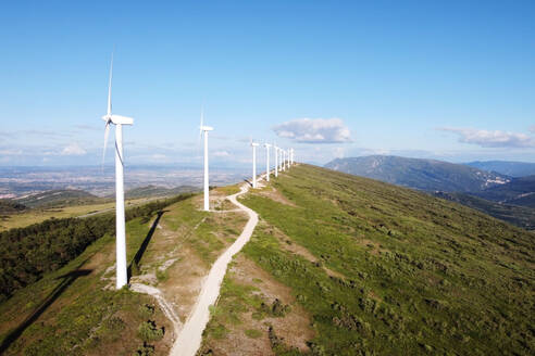 Aerial view of windmills farm for renewable energy production on beautiful blue sky. Wind power turbines generating clean renewable energy for sustainable development. High quality 4k footage.. Aerial view of windmills farm for renewable energy production on beautiful blue sky. Wind power turbines generating clean renewable energy for sustainable development - INGF12830