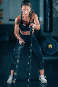 Agility training, woman exercising with rope in a gym. - INGF12836