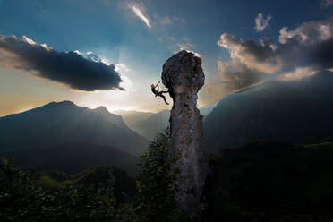 Double rope rappelling of a climber from the tip of a rock in a fairytale landscape. - INGF12852