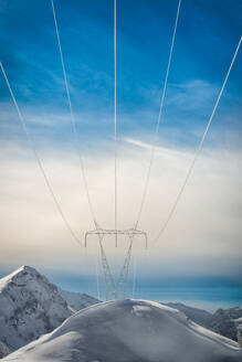 Pylons covered with snow in the high mountains carry energy downstream - INGF12853