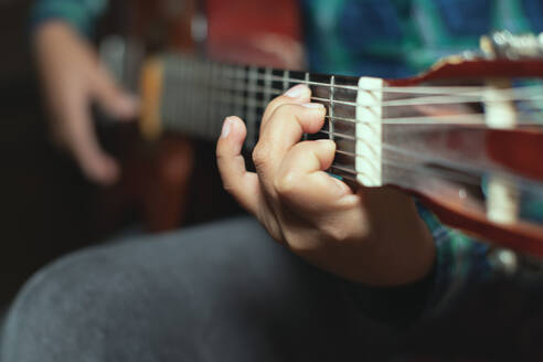 Left hand detail of a child with chord on classical guitar - INGF12855