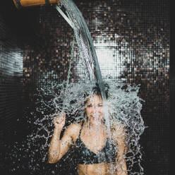Wooden Bucket with Cold Water in Spa Center.. Woman Taking a Cold Shower from Ice Bucket. - INGF12864