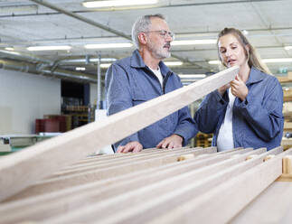 Carpenters examining plank at factory - CVF02523