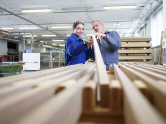 Carpenters with wooden plank in factory - CVF02531