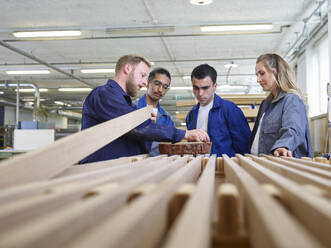 Carpenter teaching trainees about wood quality in factory - CVF02551