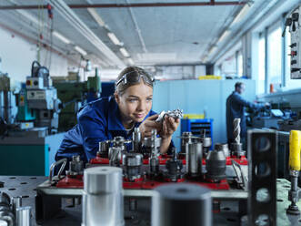 Metal worker learning to control CNC tool in factory - CVF02552