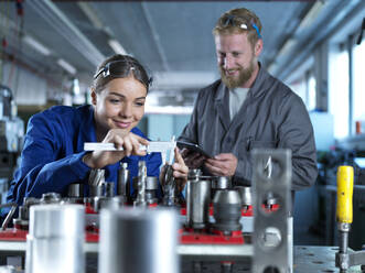Lächelnder Auszubildender, der in der Fabrik lernt, CNC-Werkzeuge zu messen - CVF02557