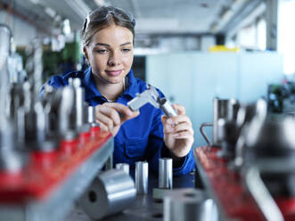 Smiling blue-collar worker checking CNC tool in factory - CVF02571