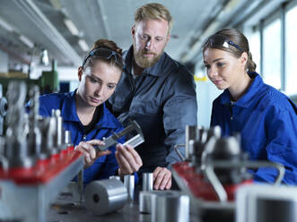 Auszubildende lernen mit Metallarbeitern im Werk das Messen von CNC-Werkzeugen - CVF02582