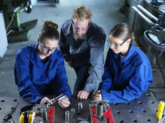 Industry worker teaching trainees to measure CNC tool in factory - CVF02584