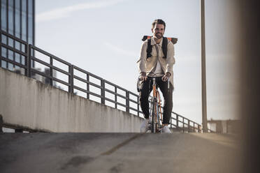 Mann fährt Fahrrad vor dem Himmel an einem sonnigen Tag - UUF30506