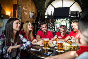 Gruppe von Freunden, die ihre Fußballmannschaft im Pub anfeuern - Gruppe von Fußballfans, die sich in einer Bar treffen und feiern - DMDF05531