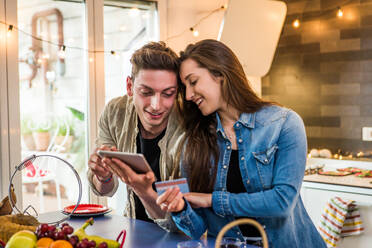 Beautiful young couple of lovers shopping online on a computer tablet - DMDF05562