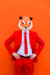 Cooler Mann trägt 3d Origami-Maske mit stilvollen farbigen Kleidung - Kreatives Konzept für die Werbung, Tierkopf Maske tun lustige Dinge auf bunten Hintergrund - DMDF05578