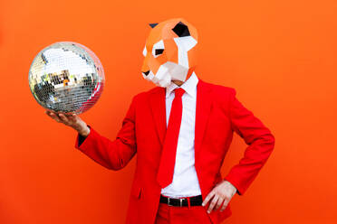 Cooler Mann trägt 3d Origami-Maske mit stilvollen farbigen Kleidung - Kreatives Konzept für die Werbung, Tierkopf Maske tun lustige Dinge auf bunten Hintergrund - DMDF05579