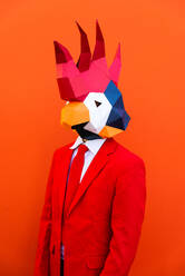 Cooler Mann trägt 3d Origami-Maske mit stilvollen farbigen Kleidung - Kreatives Konzept für die Werbung, Tierkopf Maske tun lustige Dinge auf bunten Hintergrund - DMDF05590