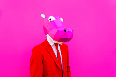 Cooler Mann trägt 3d Origami-Maske mit stilvollen farbigen Kleidung - Kreatives Konzept für die Werbung, Tierkopf Maske tun lustige Dinge auf bunten Hintergrund - DMDF05598