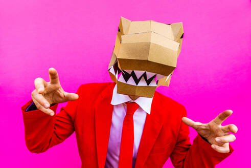 Cooler Mann trägt 3d Origami-Maske mit stilvollen farbigen Kleidung - Kreatives Konzept für die Werbung, Tierkopf Maske tun lustige Dinge auf bunten Hintergrund - DMDF05600