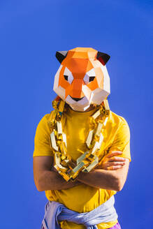 Cooler Mann trägt 3d Origami-Maske mit stilvollen farbigen Kleidung - Kreatives Konzept für die Werbung, Tierkopf Maske tun lustige Dinge auf bunten Hintergrund - DMDF05620