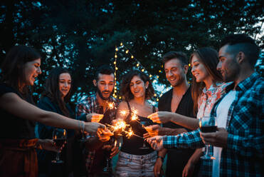 Group of young happy friends having pic-nic outdoors - People having fun and celebrating while grilling ata barbacue party in a countryside - DMDF05652