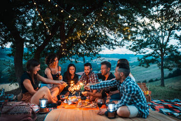 Group of young happy friends having pic-nic outdoors - People having fun and celebrating while grilling ata barbacue party in a countryside - DMDF05658