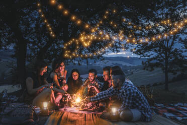 Group of young happy friends having pic-nic outdoors - People having fun and celebrating while grilling ata barbacue party in a countryside - DMDF05659