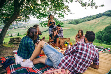 Group of young happy friends having pic-nic outdoors - People having fun and celebrating while grilling ata barbacue party in a countryside - DMDF05663