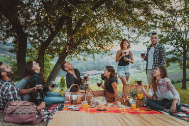 Group of young happy friends having pic-nic outdoors - People having fun and celebrating while grilling ata barbacue party in a countryside - DMDF05665