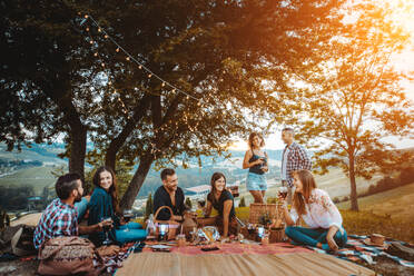 Group of young happy friends having pic-nic outdoors - People having fun and celebrating while grilling ata barbacue party in a countryside - DMDF05666