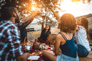 Group of young happy friends having pic-nic outdoors - People having fun and celebrating while grilling ata barbacue party in a countryside - DMDF05671